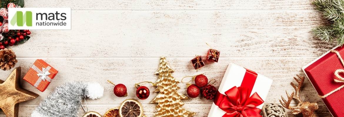 Festive ferns and Christmas presents and decorations on wooden flooring